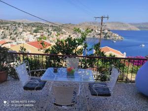 a table and chairs on a balcony with a view of the water at Giorgina's house: Aegean view in Symi