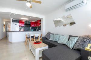 een woonkamer met een bank en een tafel en een keuken bij Dolce Vita in Alcudia