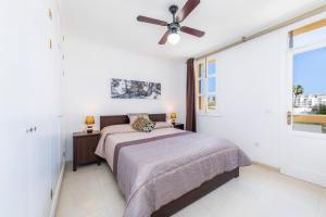 1 dormitorio con 1 cama y ventilador de techo en Dolce Vita, en Alcudia