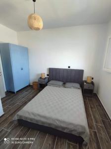 a bedroom with a large bed and a blue cabinet at Giorgina's house: Aegean view in Symi