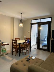een woonkamer met een bank en een tafel en stoelen bij Vivere Condominium in Vigan