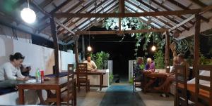 un grupo de personas sentadas en mesas en un restaurante en Aqua Blue, en Arugam Bay