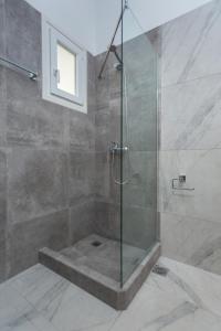 a shower with a glass door in a bathroom at Villa Zeta in Chrissi Akti