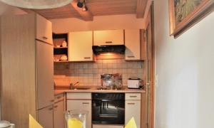 a small kitchen with white cabinets and a black oven at Ferienwohnung Stoiber Wolfgang in Regen