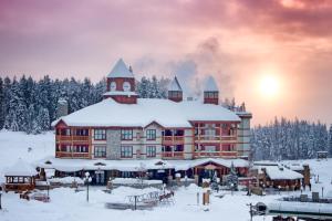 eine große Lodge im Schnee mit schneebedeckten Bäumen in der Unterkunft Polaris Lodge in Kimberley