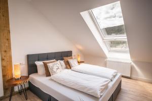 a bedroom with a large bed with a skylight at Hotel Großbach in Menzenschwand