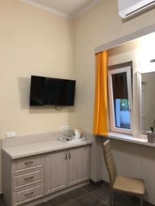 a bathroom with a sink and a tv on the wall at Szem-s Vendégház in Balatonszemes