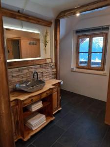 ein Bad mit einem Waschbecken und einem Spiegel in der Unterkunft Berggasthof Schwaigerhof in Haus im Ennstal