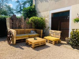 un patio con 2 bancos, una mesa y una valla en Le Chardon, en Chardonnay