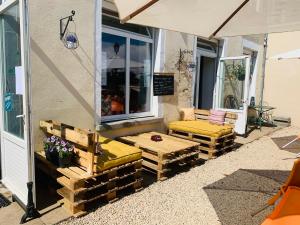 patio z ławkami, stołem i parasolem w obiekcie Le Chardon w mieście Chardonnay