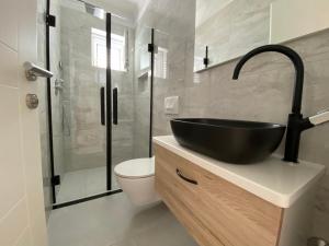 een badkamer met een zwarte wastafel en een toilet bij Emanuela 2 in Novalja