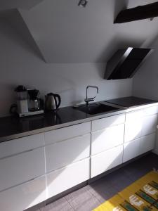 uma cozinha com armários brancos e um balcão preto em Near Legoland, Skolevej 25, 6640 Lunderskov em Lunderskov