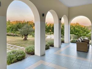 a patio with arches and a view of a park at TOSCANINA Garni Hotel in Dobrovo