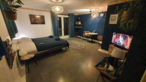 a bedroom with a bed and a television in it at De Remise in Hengelo
