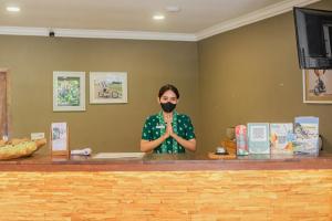 a man standing behind a counter wearing a mask at Coconut Lodge Resort in Jepara