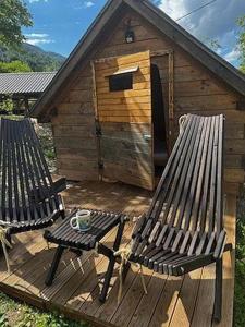 eine Holzterrasse mit zwei Bänken und einem Hundehaus in der Unterkunft Krampez in Kobarid