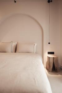 una camera da letto con un grande letto bianco e un tavolo di Om Living Afitos ad Áfitos