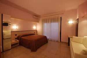 Habitación de hotel con cama y sofá en Hotel Clara, en Tortoreto Lido