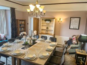 uma sala de jantar com uma mesa longa e cadeiras em Hackney House em Richmond