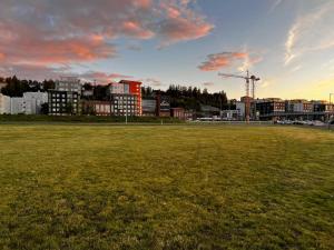 a large field with a city in the background at Uusi upea asunto järvinäköalalla ja autohallilla in Tampere