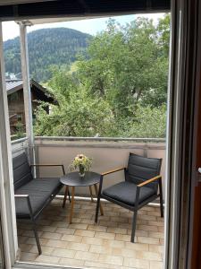 un balcon avec deux chaises et une table avec vue dans l'établissement Spacious 2 bedroom apartment Zell-am-See town center, à Zell am See