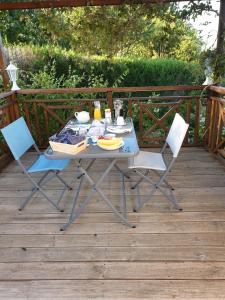 a table and two chairs on a wooden deck at Les érables in Saint-Sulpice-les-Feuilles