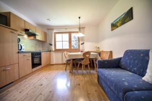 a living room with a blue couch and a table at Schoenau Bio & SPA Family Apartments in San Pietro in Laion
