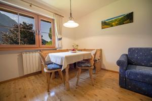 a dining room with a table and chairs and a couch at Schoenau Bio & SPA Family Apartments in Ortisei