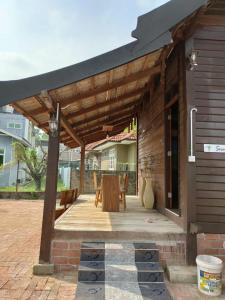 The Serai Cottage Downtown Hotel في كوالا ترغكانو: بريغولا خشبي مع طاولة وكراسي على الفناء