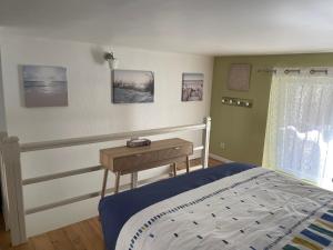 a bedroom with a bed and a wooden table at L’EFFERVESCENT in Reims