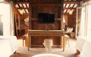 a living room with a tv on a wooden wall at Amar Boutique Hotel in Canggu