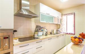 a kitchen with white cabinets and a bowl of fruit at Amazing Apartment In Los Alcázares in Los Alcázares