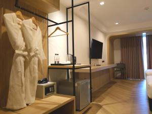 a hotel room with a robe hanging on a wall at Sann Boutique Hotel in Chiang Rai