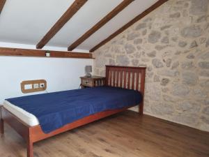 1 dormitorio con 1 cama en una pared de piedra en Apartment Maestro, en Ugljan