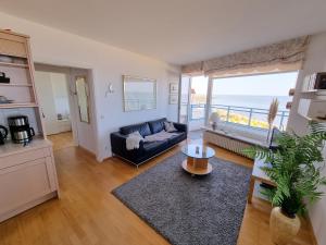 ein Wohnzimmer mit Couch und Blick aufs Meer in der Unterkunft Silbermöwe - Traumhafter Meerblick in Cuxhaven