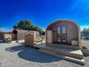 Cabaña de madera pequeña con terraza de madera en Bryn Glamping, en Coychurch