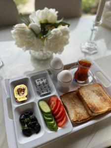 una bandeja de comida con tostadas y verduras en una mesa en Fakher Yanbu Hotel en Yanbu