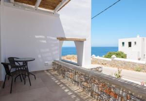 a patio with a table and chairs looking out at the ocean at Araklos II in Aegiali