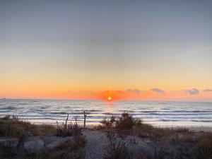 a sunset over the ocean with a sandy beach at La casa di Alice in Venice