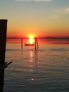 two people in a boat in the water at sunset at La casa di Alice in Venice