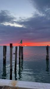 a group of wooden posts in the water at sunset at La casa di Alice in Venice