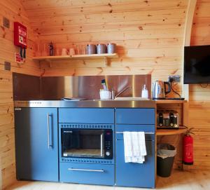 a kitchen with a blue oven and a sink at Bryn Glamping in Coychurch