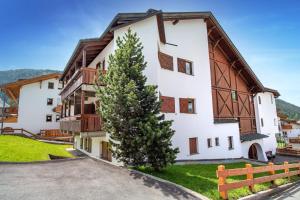 ein Gebäude mit einem Baum davor in der Unterkunft Apartment Nogler Frieda in Wolkenstein in Gröden