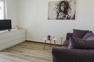 a living room with a couch and a tv and a table at FrAn in Slavonski Brod