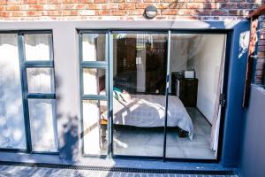 a bedroom with sliding glass doors and a bed in it at Peaceful 1-bedroom flatlet, 10 min from the beach in Cape Town