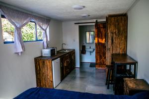 a room with a kitchen with a sink and a microwave at Peaceful 1-bedroom flatlet, 10 min from the beach in Cape Town