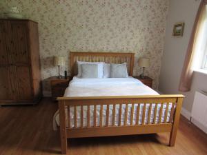 a bedroom with a bed with a wooden bed frame at Dungimmon House in Ballyconnell