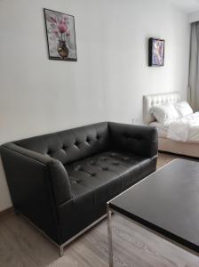 - un canapé en cuir noir dans le salon avec un lit dans l'établissement One Bukit Ceylon KLCC, à Kuala Lumpur
