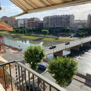 un puente sobre un río con coches en él en Apartamento completamente reformado en el casco antiguo con vistas al rio, en Balaguer