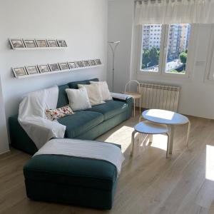 a living room with a blue couch and a table at Apartamento completamente reformado en el casco antiguo con vistas al rio in Balaguer